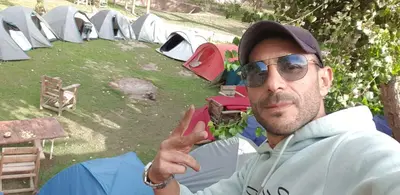 a man sitting in front of a group of tents at slimane in Aït Hallouane