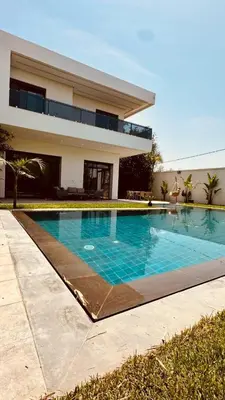 a swimming pool in front of a house at Villa 3chambres Aéroport de Fès Piscine Jacuzzi in Oulad Tayeb