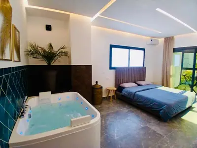 a bedroom with a tub and a bed in it at Villa 3chambres Aéroport de Fès Piscine Jacuzzi in Oulad Tayeb