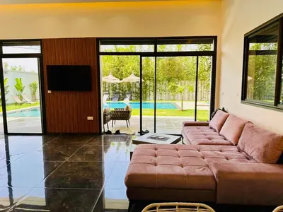 a living room with a couch and a tv at Villa 3chambres Aéroport de Fès Piscine Jacuzzi in Oulad Tayeb