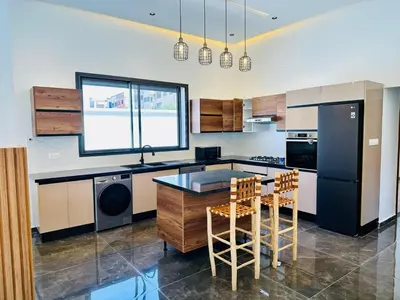 a kitchen with a black refrigerator and a table at Villa 3chambres Aéroport de Fès Piscine Jacuzzi in Oulad Tayeb