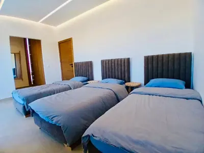 a room with three beds with blue pillows at Résidence Fès Garden Piscine privé ou Jacuzzi in Oulad Tayeb