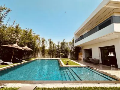 a swimming pool in front of a house at Résidence Fès Garden Piscine privé ou Jacuzzi in Oulad Tayeb