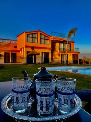 three blue and white glasses on a tray with a house at Tynass Ferme - Fes in Fès