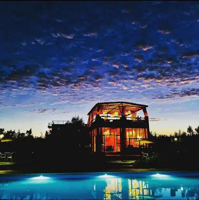 a large glass house at night with its lights on at Tynass Ferme - Fes in Fès