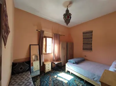 a bedroom with a bed and a mirror at Asmaa Guesthouse Todra in Tinerhir