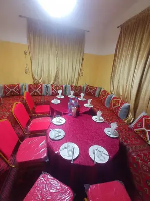 a room with a pink table and red chairs at Asmaa Guesthouse Todra in Tinerhir