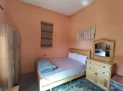 a small bedroom with a bed and a mirror at Asmaa Guesthouse Todra in Tinerhir