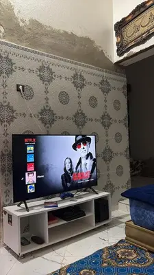 a flat screen tv sitting on a stand in a room at dar cherfa lbettaouien in Oulad Akkou
