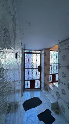 a bathroom with two windows in a room at dar cherfa lbettaouien in Oulad Akkou