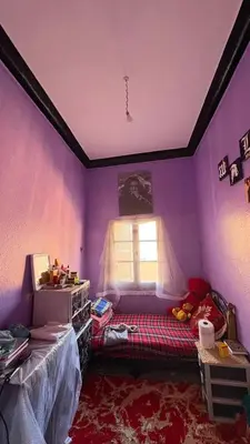 a purple room with a bed and a window at dar cherfa lbettaouien in Oulad Akkou