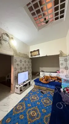a room with two beds and a flat screen tv at dar cherfa lbettaouien in Oulad Akkou