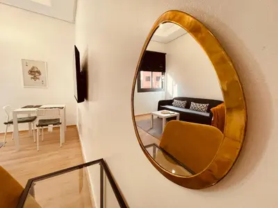 a mirror hanging on a wall in a living room at Zyon Family in Oulad Akkou