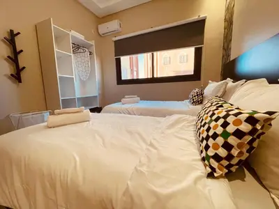 a bedroom with two white beds and a window at Zyon Family in Oulad Akkou
