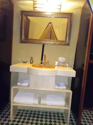 a bathroom with a sink and a mirror and towels at Amandesertcamp in Lac Yasmins