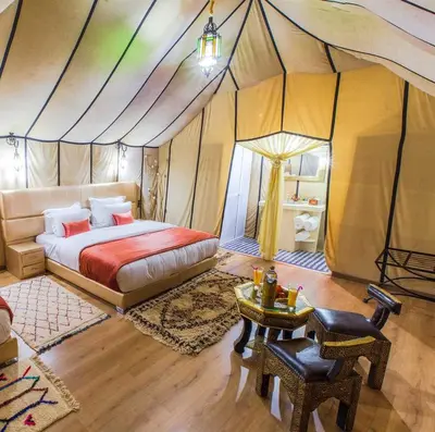 a bedroom with a bed in a tent at Zeus Sahara Luxury Camp in Merzouga