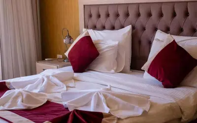 a bedroom with a bed with red and white pillows at Zeus Sahara Luxury Camp in Merzouga