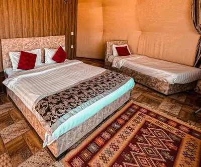 a bedroom with two beds and a chair in it at Zeus Sahara Luxury Camp in Merzouga