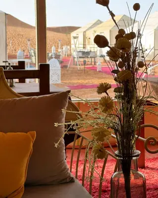 a vase filled with flowers sitting on top of a couch at Zeus Sahara Luxury Camp in Merzouga
