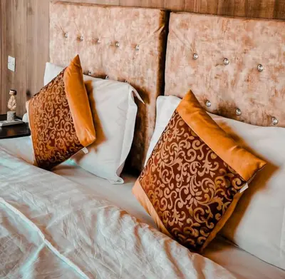 a bed with three pillows on top of it at Zeus Sahara Luxury Camp in Merzouga