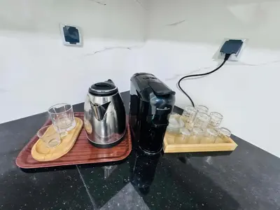 a coffee maker and glasses on a table at URBAN WHITE Elya 2 in Beni Mellal