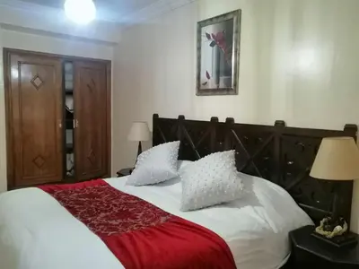 a bedroom with a bed with a red blanket and pillows at complex mousse in Oulad Akkou