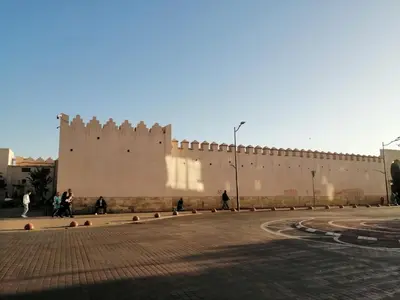 a large wall with people walking in front of it at complex mousse in Oulad Akkou