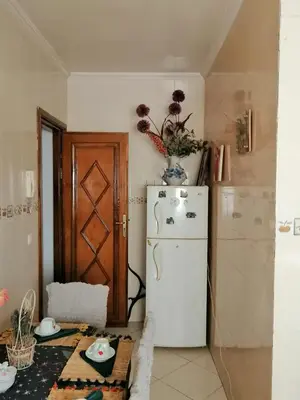 a small kitchen with a white refrigerator and a table at complex mousse in Oulad Akkou