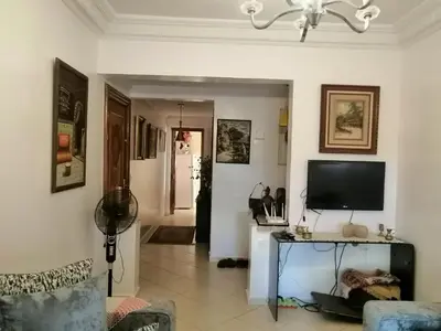a living room with a television and a table at complex mousse in Oulad Akkou