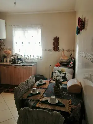 a living room with a table and a kitchen at complex mousse in Oulad Akkou