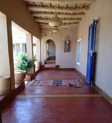 an empty hallway of a house with a blue door at Tigmi N'Dounit Lodge et Nature in Boumalne