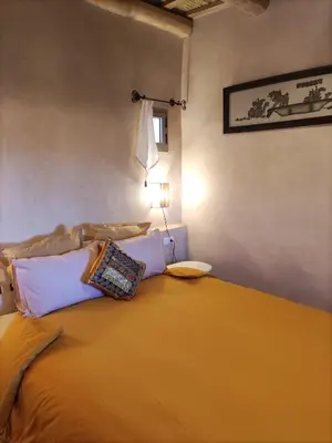 a bedroom with a large orange bed with a lamp at Tigmi N'Dounit Lodge et Nature in Boumalne