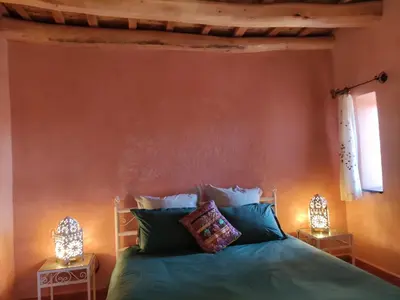 a bedroom with a bed with two lamps on either side at Tigmi N'Dounit Lodge et Nature in Boumalne