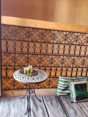 a table in a room with a patterned wall at Tigmi N'Dounit Lodge et Nature in Boumalne