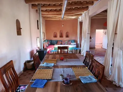 a dining room with a table and a couch at Tigmi N'Dounit Lodge et Nature in Boumalne