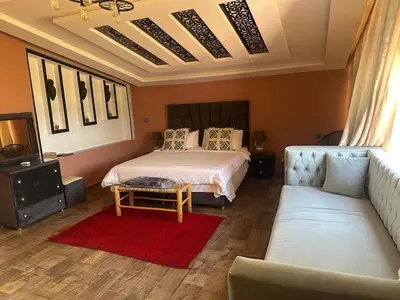 a bedroom with a bed and a couch at Tynass Ferme - Chambre Zalagh Fes