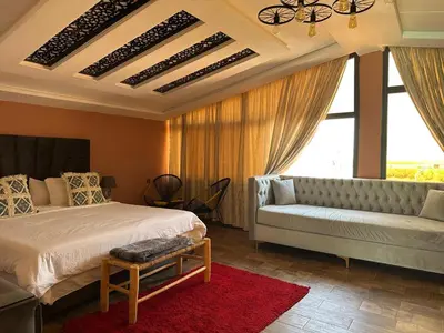 a bedroom with a bed and a couch and a window at Tynass Ferme - Chambre Zalagh Fes