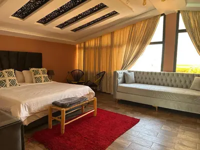 a bedroom with a bed and a couch and a window at Tynass Ferme - Chambre Zalagh Fes