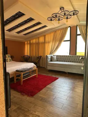 a bedroom with a bed and a couch and a window at Tynass Ferme - Chambre Zalagh Fes