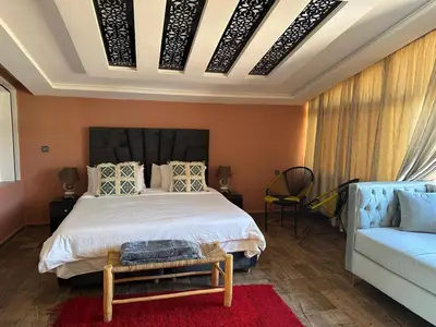 a bedroom with a large bed and a couch at Tynass Ferme - Chambre Zalagh Fes