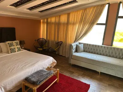 a bedroom with a bed and a couch and a window at Tynass Ferme - Chambre Zalagh Fes
