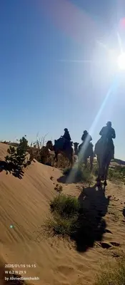 a group of people riding horses in the desert at Daraa Valley House in Mhamid