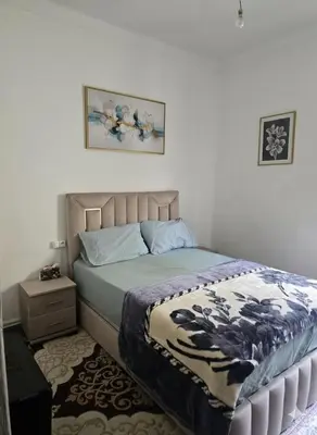 a bedroom with a bed with a blanket and a night stand at Appartement 3S in Meknès