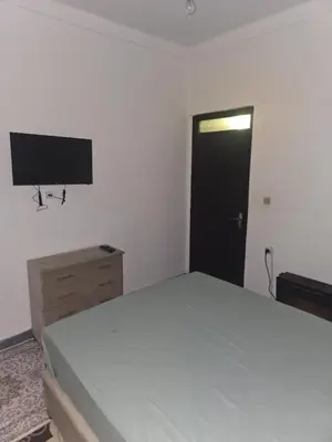 a bedroom with a bed and a flat screen tv at Appartement 3S in Meknès