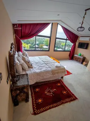 a bedroom with a bed and a large window at Tynass Ferme - Atlas Room Fes