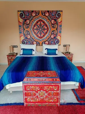 a bedroom with a bed with a colorful head board at Tynass Ferme - Chefchaouen Room - Fes