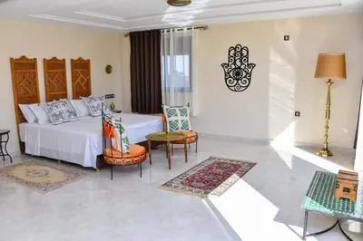a bedroom with a bed and a table and chairs at Tynass Ferme - Fez Room Fes