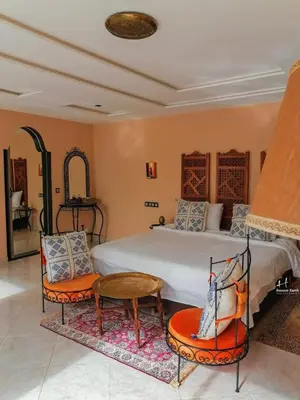 a bedroom with a bed and a table and chairs at Tynass Ferme - Fez Room Fes