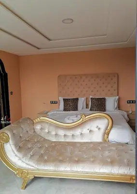 a bedroom with a large bed with a gold frame at Ferme Tynass - Paris Room With Balcony Fes