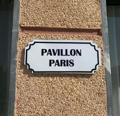 a sign on the side of a building that reads pavilion parks at Ferme Tynass - Paris Room With Balcony Fes